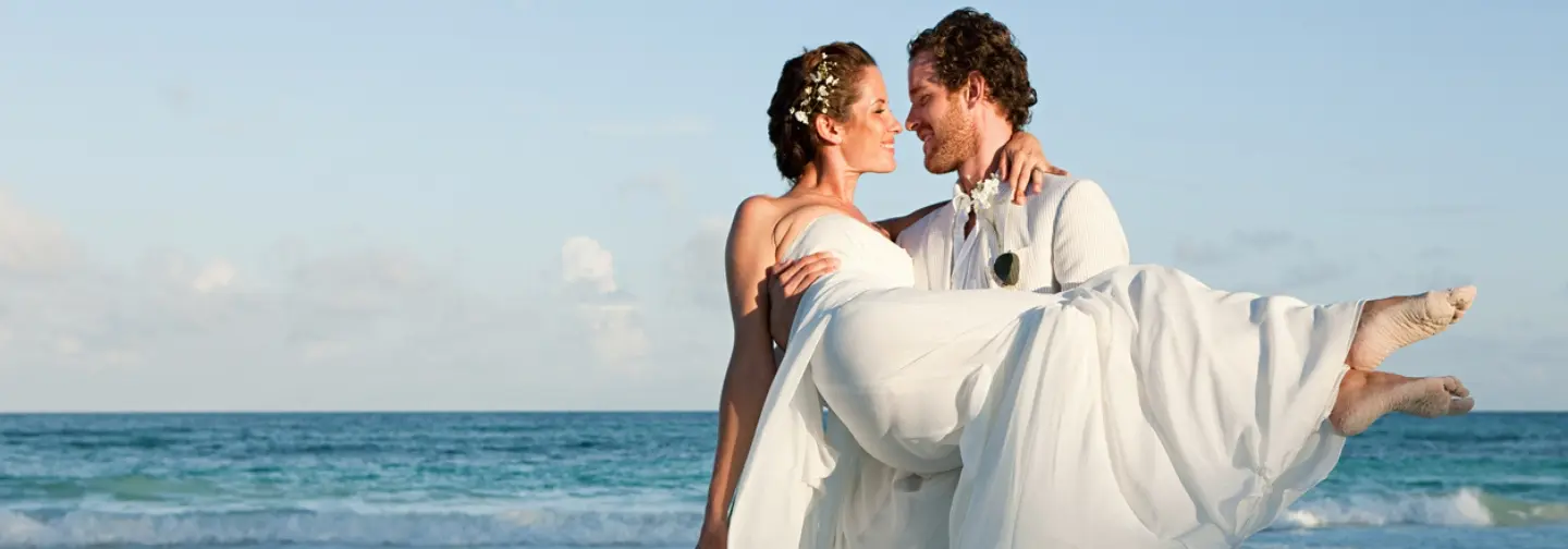 Couple de jeunes mariés au bord de la mer des Caraïbes à La Créole Beach Hotel & Spa au Gosier.