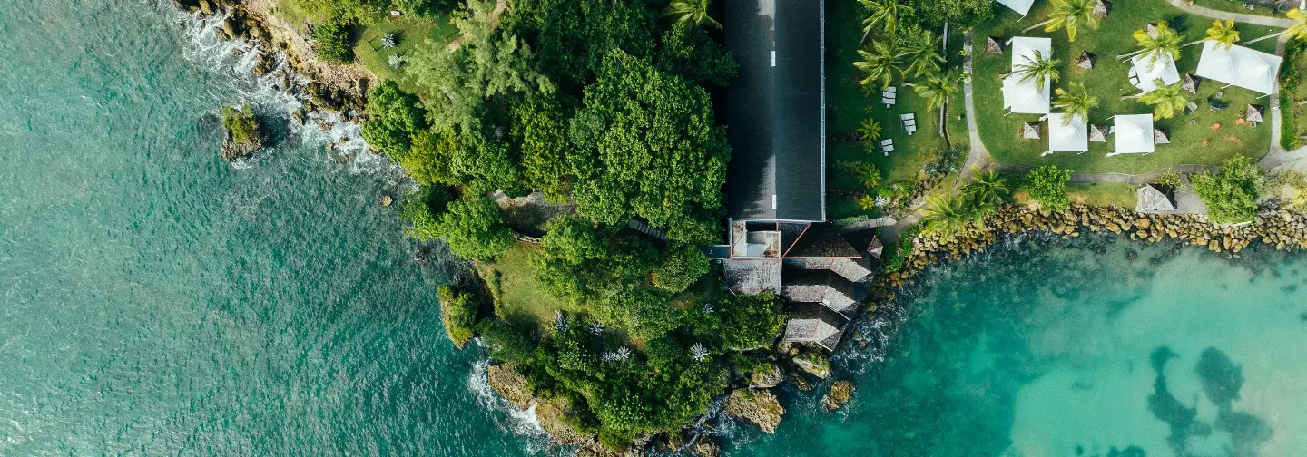 Vue aérienne de la piscine entourée de jardins tropicaux à La Créole Beach Hotel & Spa au Gosier.