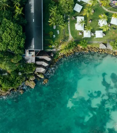 Vue aérienne de la piscine entourée de jardins tropicaux à La Créole Beach Hotel & Spa au Gosier.