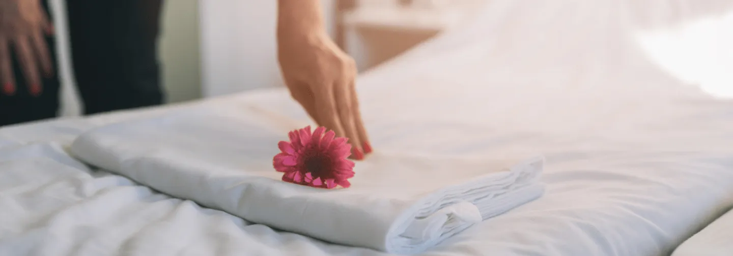 Fleur tropicale posée sur un lit préparé dans une chambre de La Créole Beach Hotel & Spa au Gosier.
