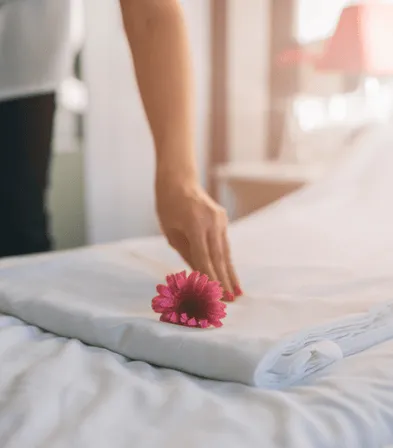 Fleur tropicale posée sur un lit préparé dans une chambre de La Créole Beach Hotel & Spa au Gosier.