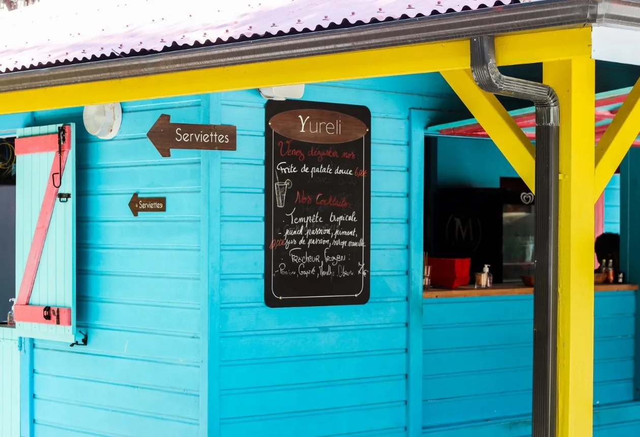 Façade colorée du Yureli Beach Bar avec menu affiché à La Créole Beach Hôtel & Spa en Guadeloupe