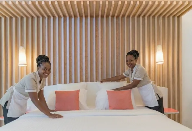 Femmes de chambre préparant un lit dans une chambre de l’hôtel La Créole Beach au Gosier en Guadeloupe.