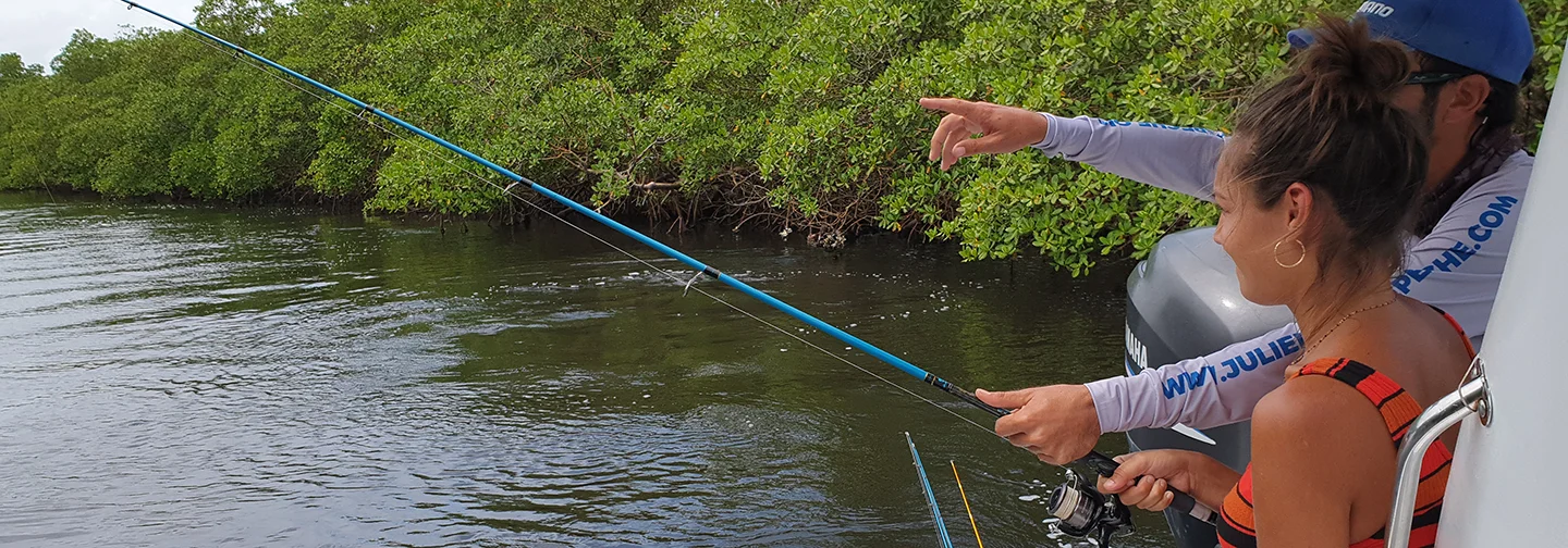 Une femme et son guide pratiquant la pêche en mer près des mangroves, une activité proposée par La Créole Beach Hôtel & Spa.