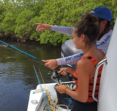 Une femme et son guide pratiquant la pêche en mer près des mangroves, une activité proposée par La Créole Beach Hôtel & Spa.