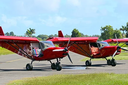ULM rouges prêts au décollage pour un vol panoramique avec La Créole Beach Hôtel & Spa.