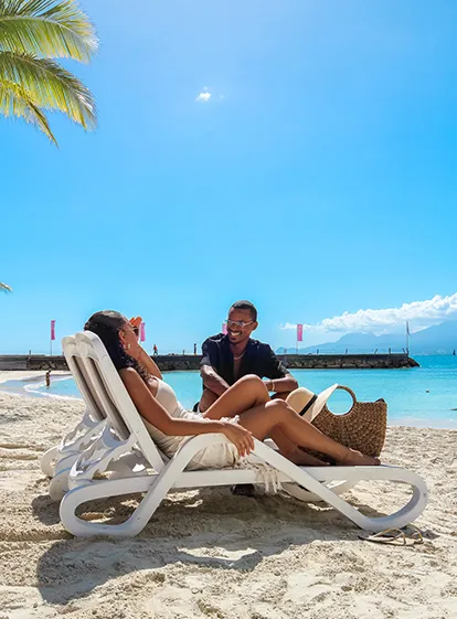 Couple se relaxant sur des transats face à la mer à La Créole Beach Hôtel & Spa en Guadeloupe
