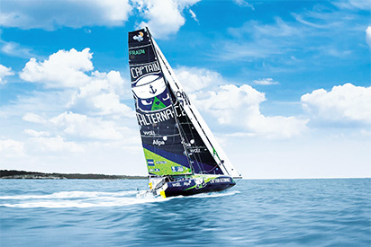 Le voilier Captain Alternance (Afpa) navigue à pleine vitesse en mer sous un ciel nuageux, une image associée à la Route du Rhum