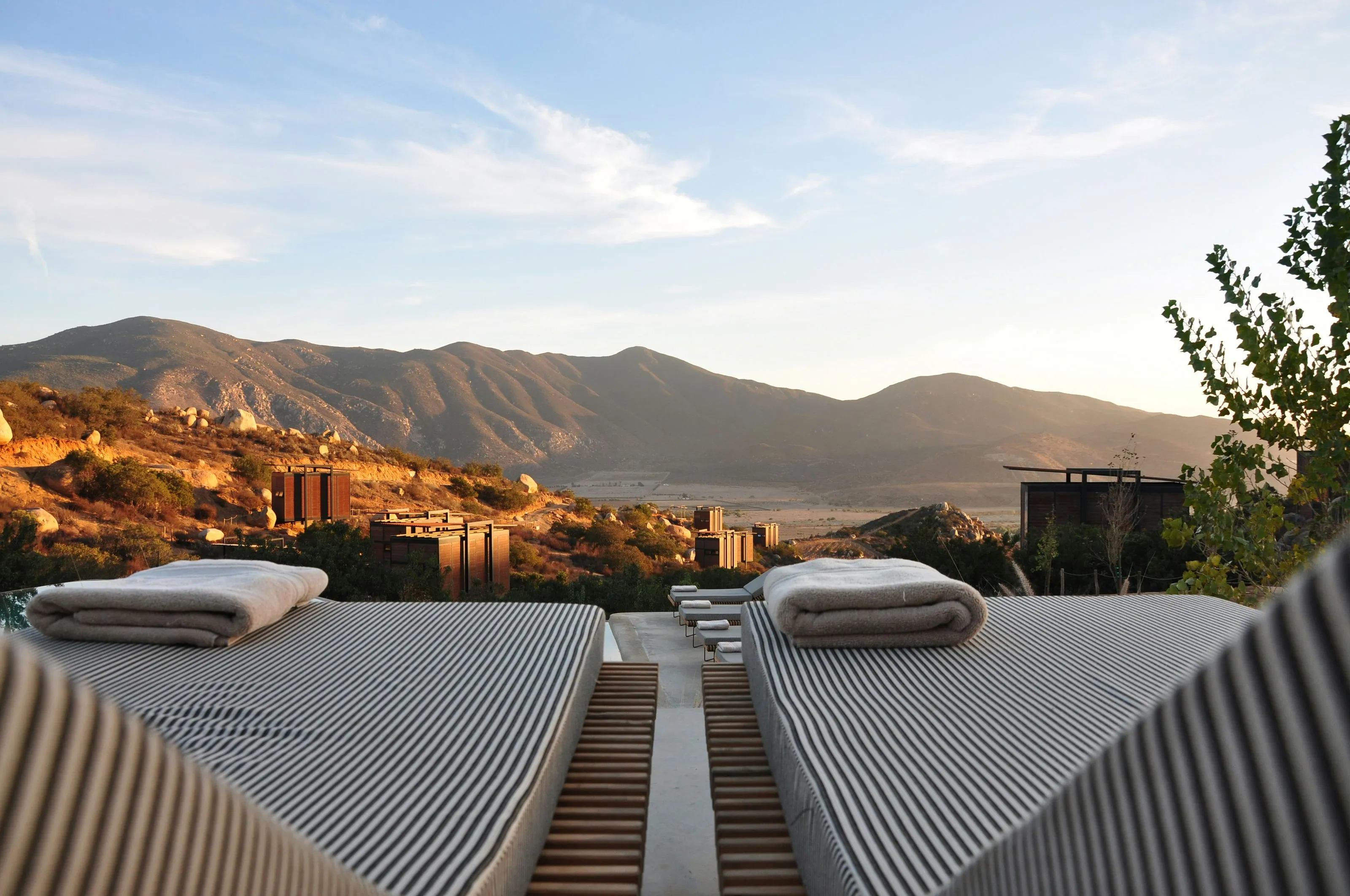 Two towels neatly arranged on a wooden deck, with a stunning view of the mountains in the background.