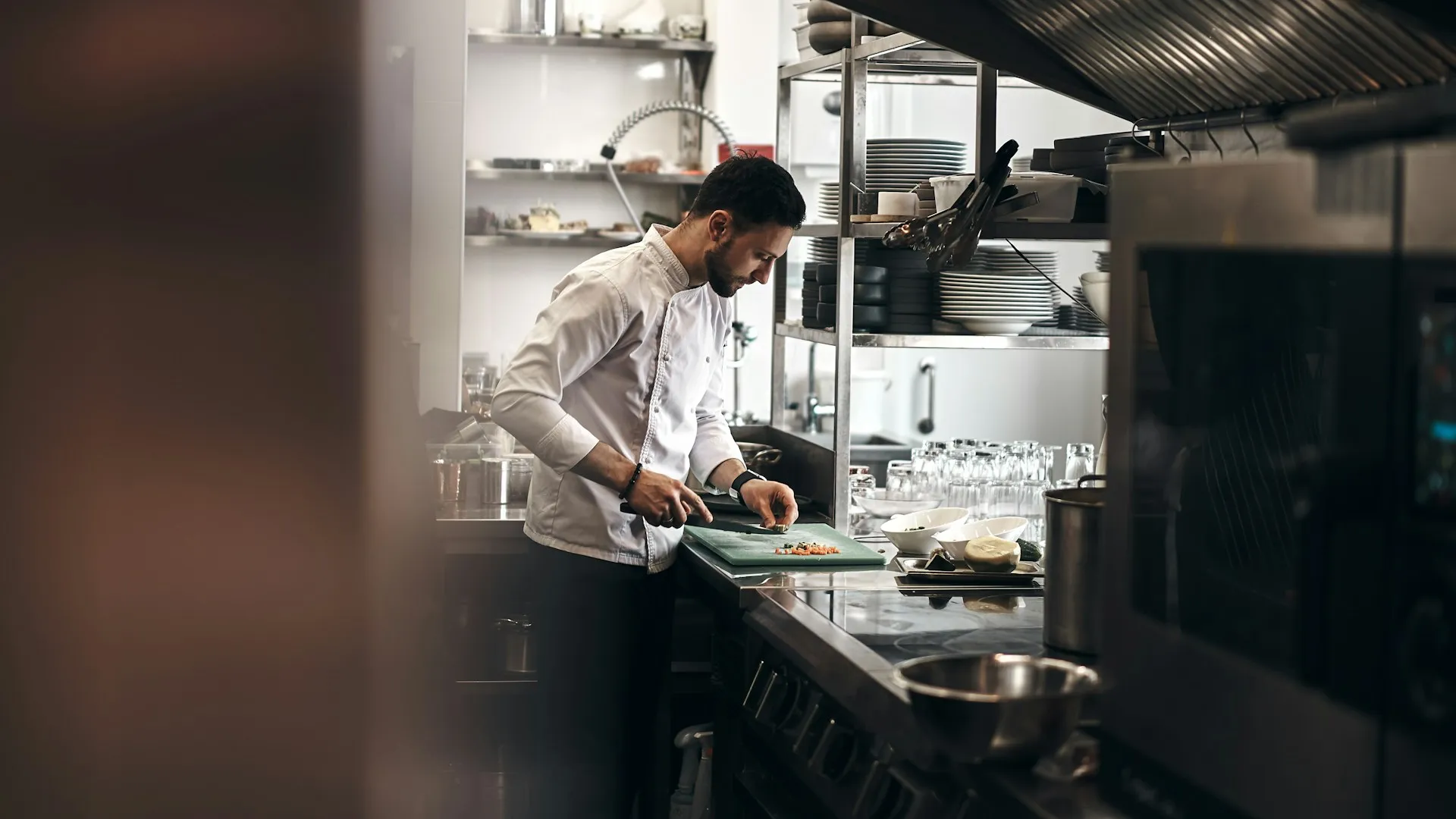A man standing in a kitchen preparing food.