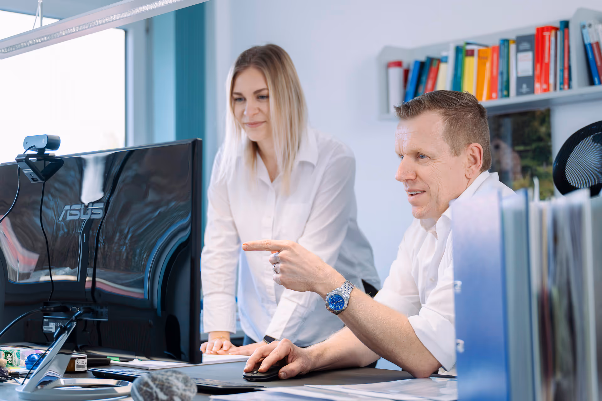 Ein Mann und eine Frau arbeiten zusammen an einem Computer in einem Büro.