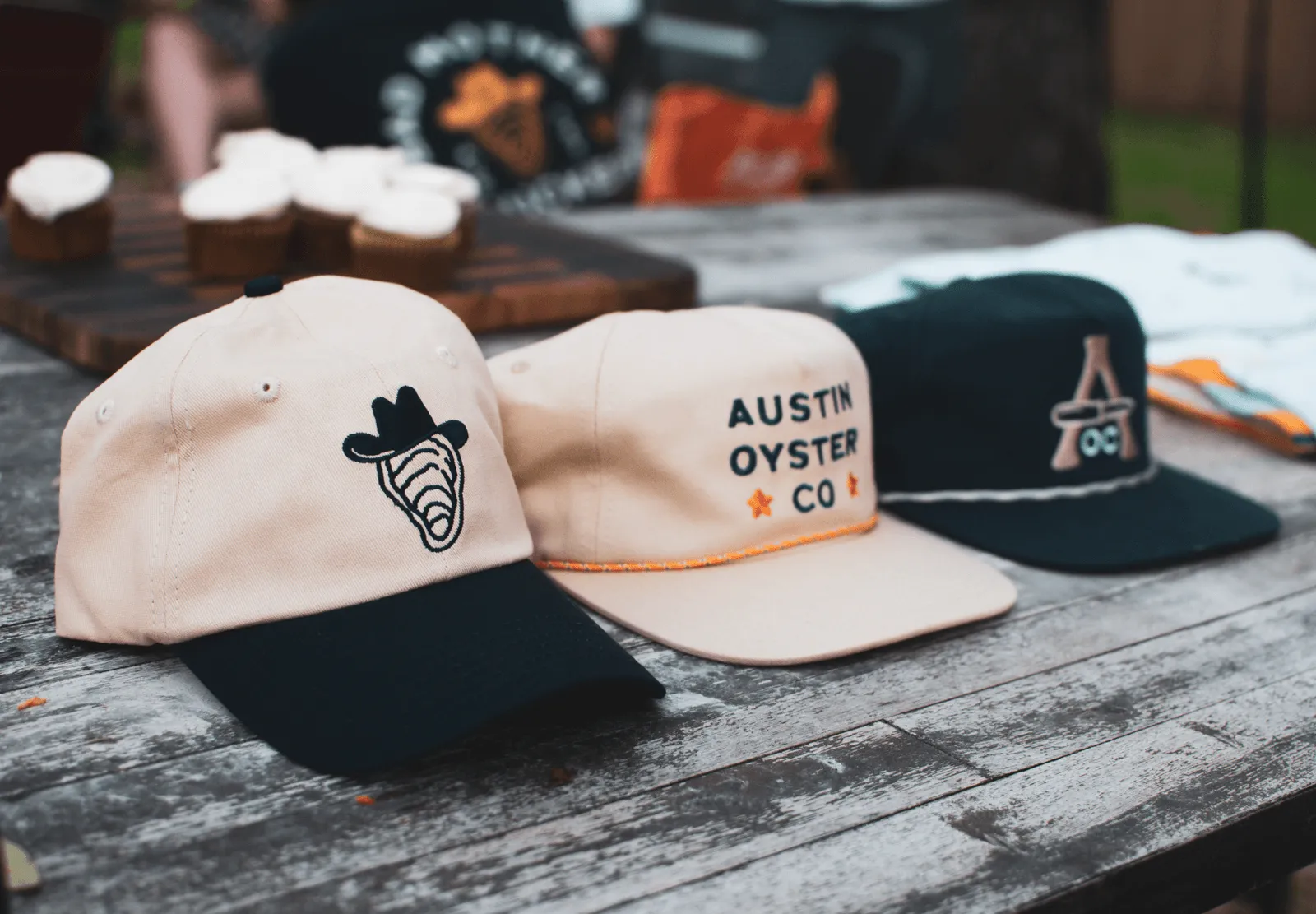 A wooden table with Austin Oyster Co. branded hats.