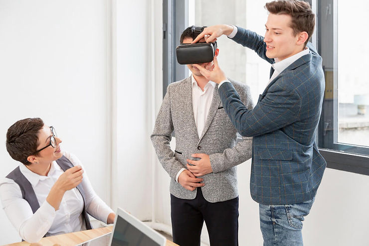 A man offers a virtual reality headset to a woman, highlighting the excitement of virtual experiences together.