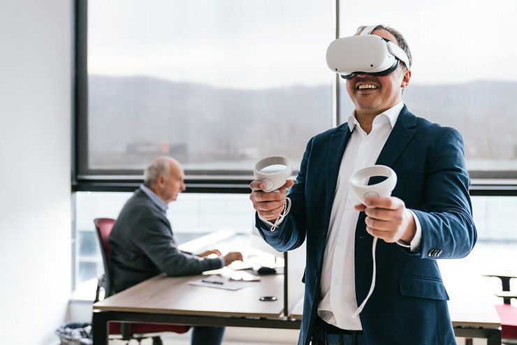 A man in a suit holds a virtual reality headset, showcasing a blend of professionalism and modern technology.