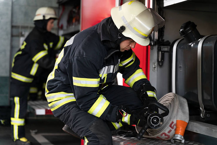 A man wearing a helmet stands confidently, showcasing safety gear in a professional setting.