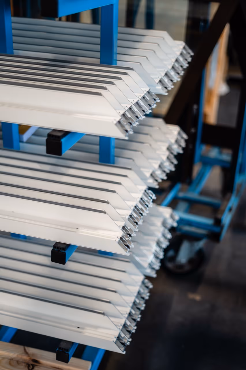 Vue de prêt de profilé en aluminium gris claire posés horizontalement sur un support bleu