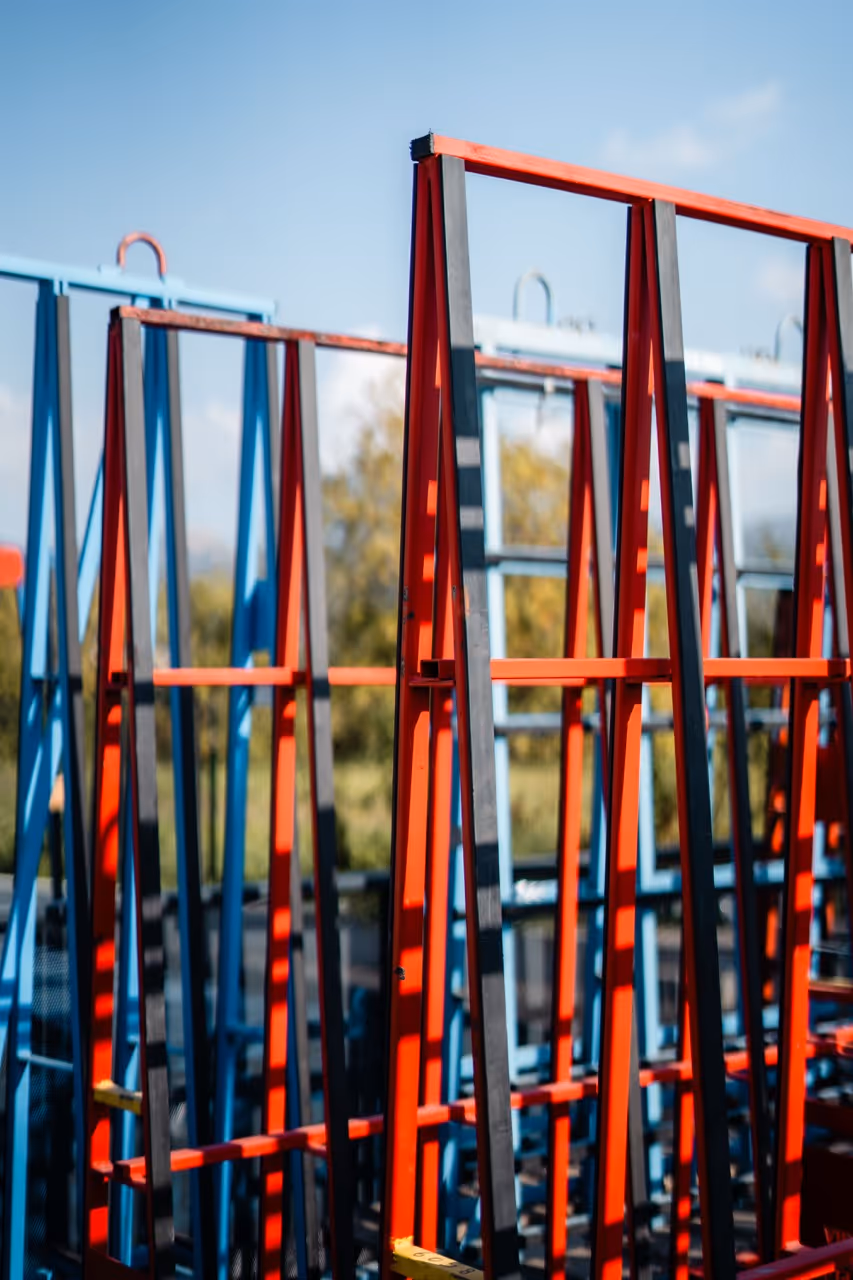 Chassis de fenêtre entreposer verticalement sur des support métallique bleu et rouge