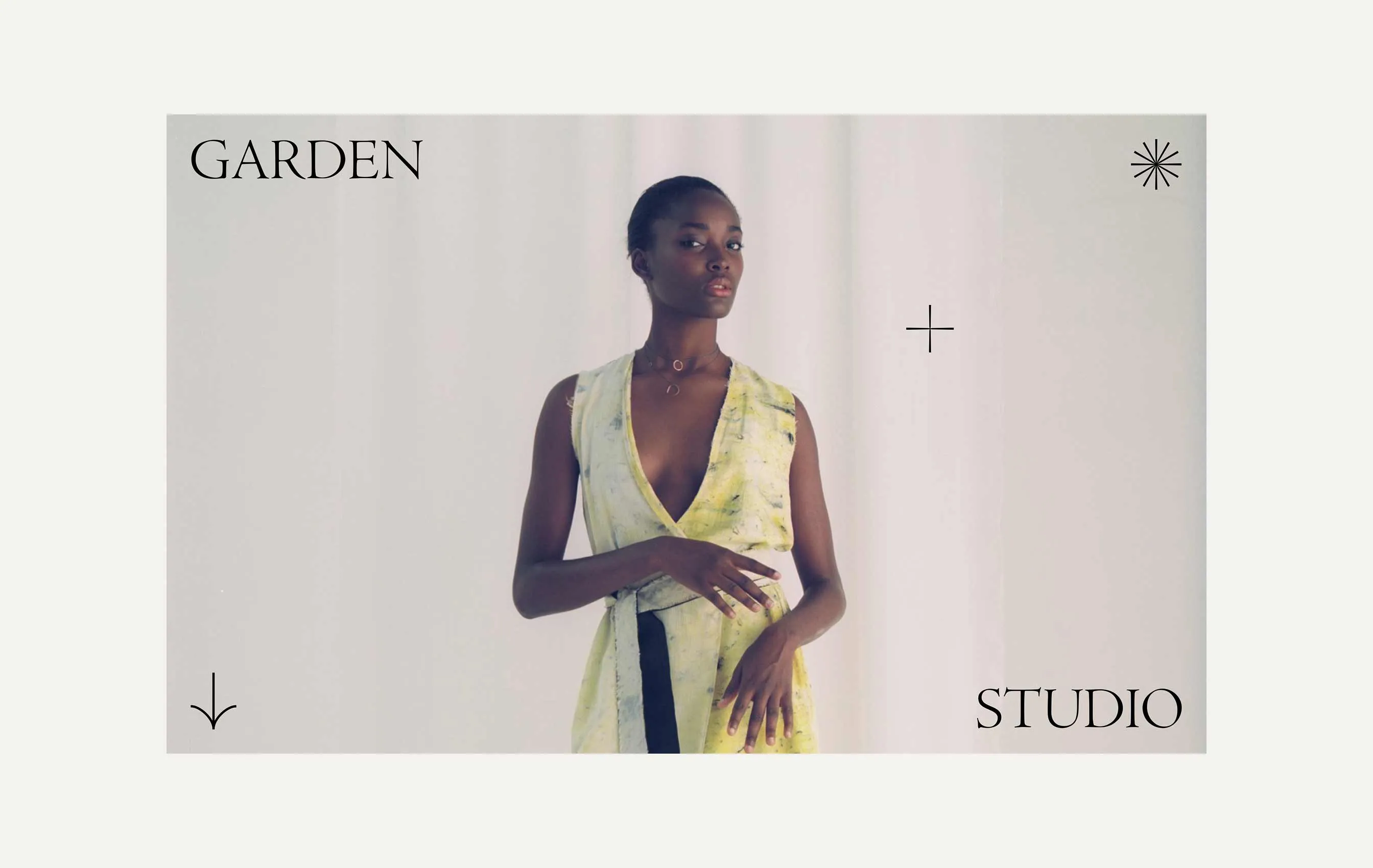 Portrait of a woman wearing a sleeveless light yellow wrap dress against a plain light background with the words 'GARDEN' and 'STUDIO'.