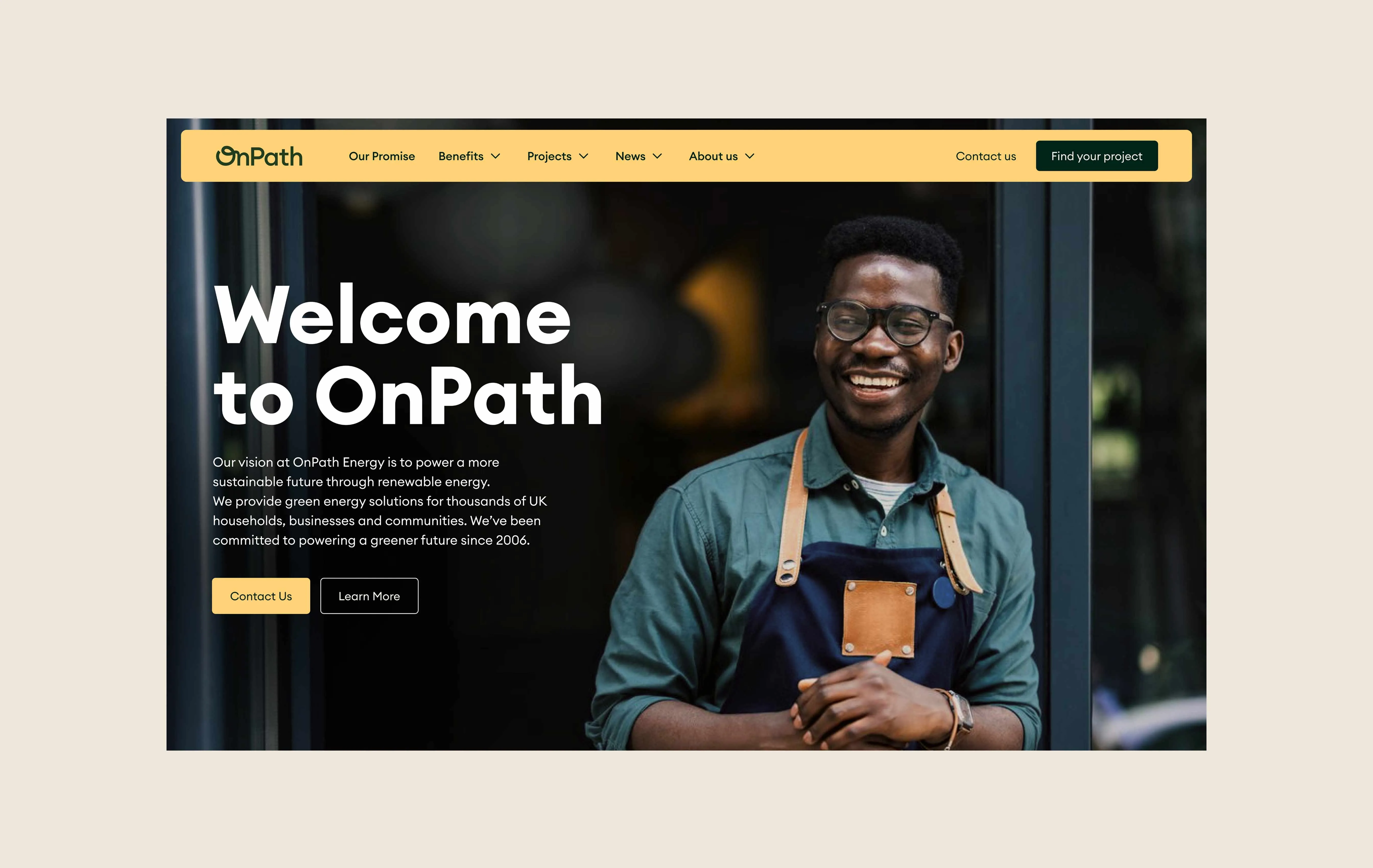 Smiling man wearing glasses and an apron standing next to a glass wall, with welcome message for energy company.