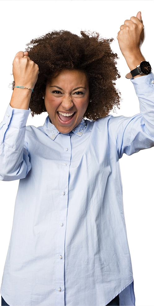 Happy woman with curly hair wearing a light blue shirt raising her fists in celebration.