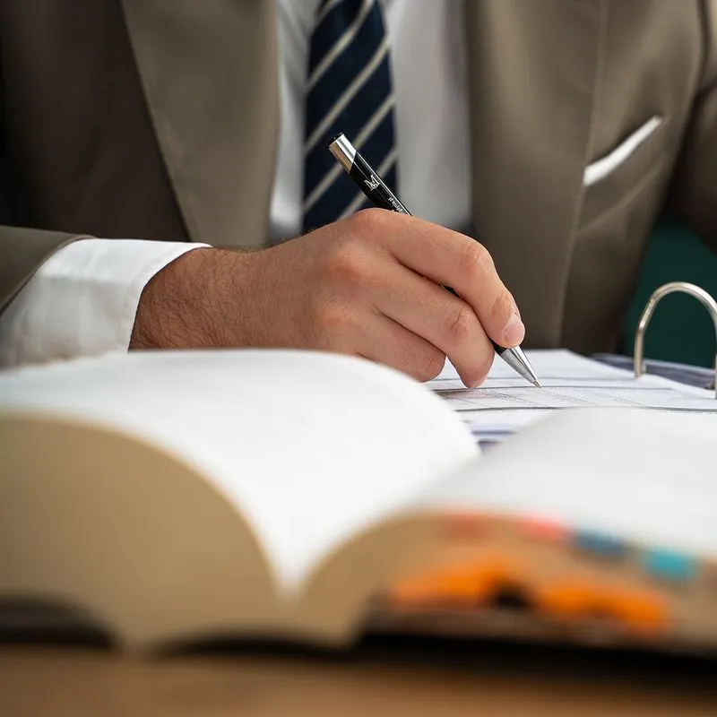 Adwokat Kancelarii Czarnota w Gdańsku przygotowuje opinię prawną, notując w dokumentach i analizując przepisy