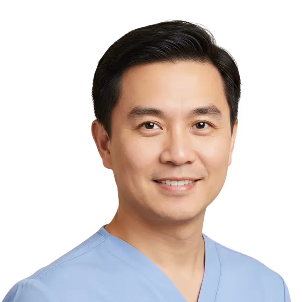 Smiling man wearing light blue medical scrubs against a transparent background.