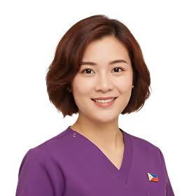 Smiling woman with short brown hair wearing a purple top with a small Philippine flag pin.