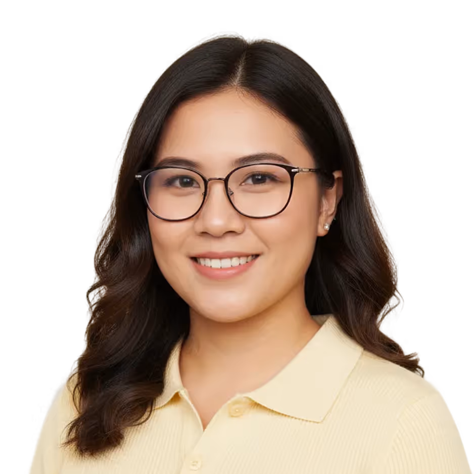 Smiling woman with dark wavy hair wearing glasses and a light yellow collared shirt.