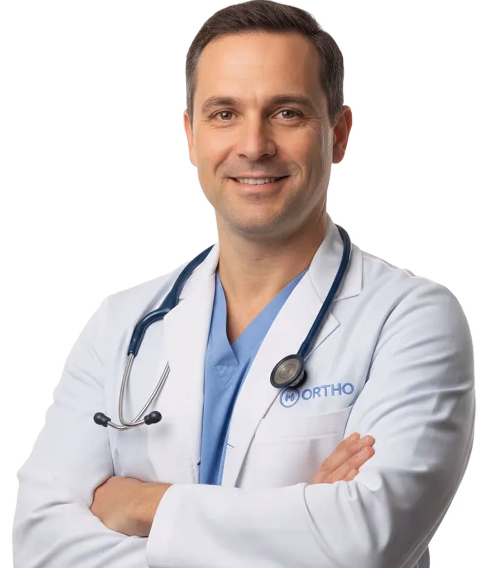 Smiling male doctor in white coat with stethoscope and blue scrubs crossing his arms.