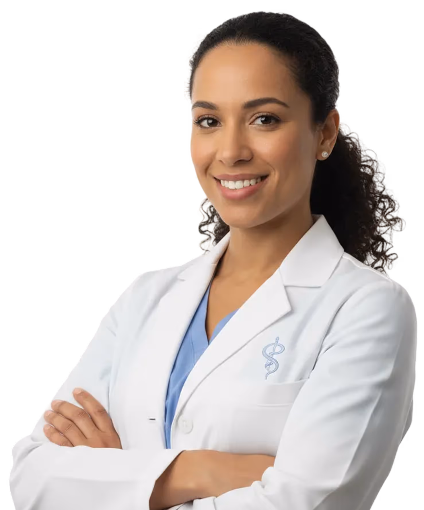 Smiling female doctor with curly hair wearing a white coat and blue scrubs, arms crossed.