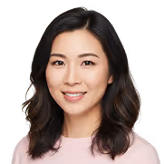 Smiling woman with shoulder-length dark hair wearing a light pink top.