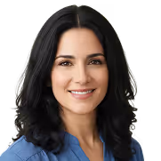 Smiling woman with long black hair wearing a blue blouse.