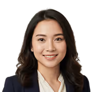 Smiling Asian woman with dark wavy hair wearing a white blouse and navy blazer.