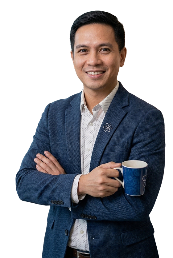 Smiling man in a blue blazer holding a blue coffee mug with crossed arms.