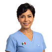 Smiling female healthcare professional in light blue scrubs with a Mexican flag pin.