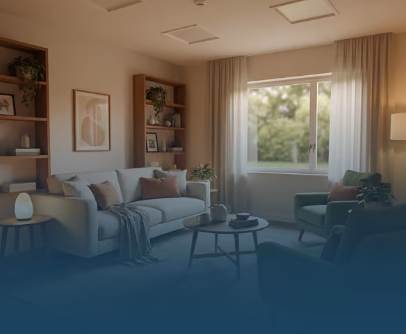 Cozy living room with light gray sofa, green armchairs, round coffee table, shelves, and window with curtains.