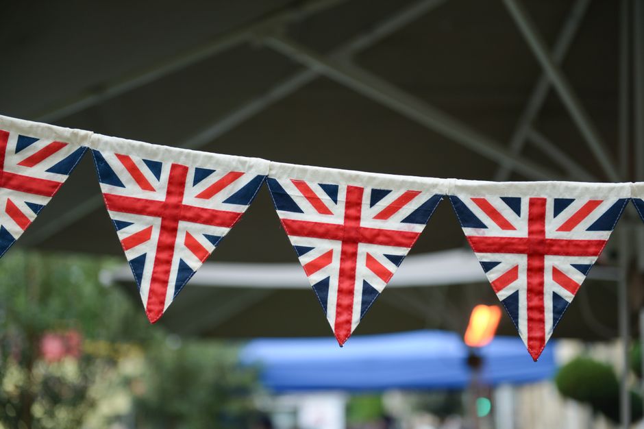 A close-up of outdoor bunting displaying Union Jack flags symbolizing British patriotism.