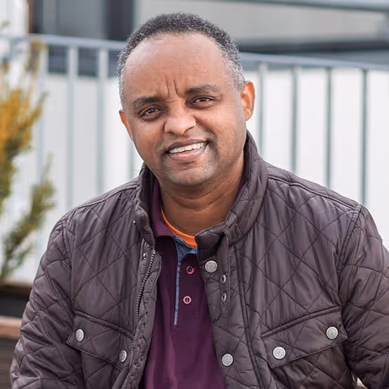 Sebhat, en renholder hos Vaskehjelp, smiler til kameraet.