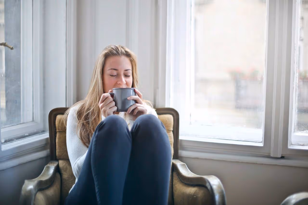 Woman holding a gray teacup.