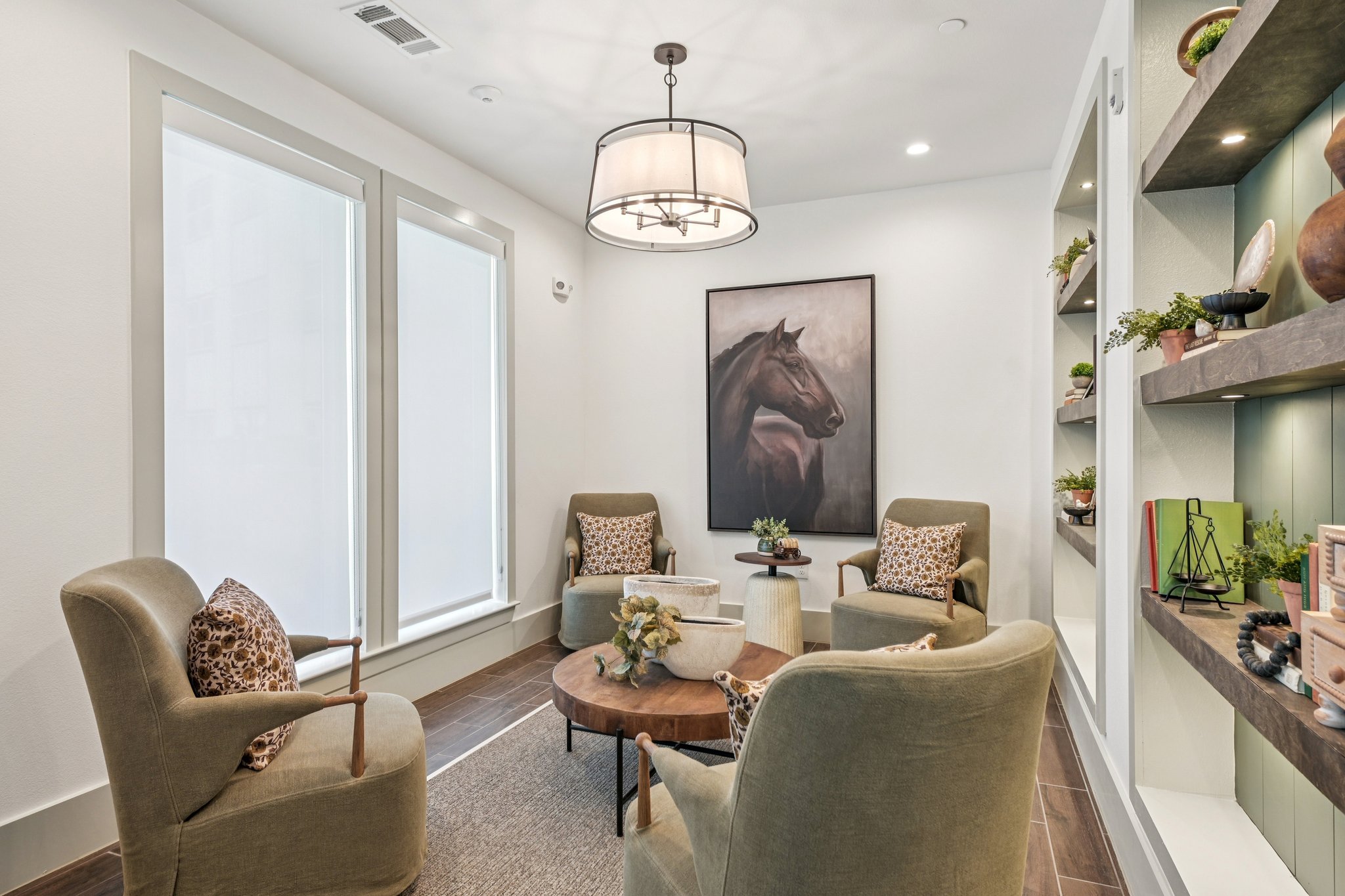 community lounge with coffee table, chairs, and decorated shelves