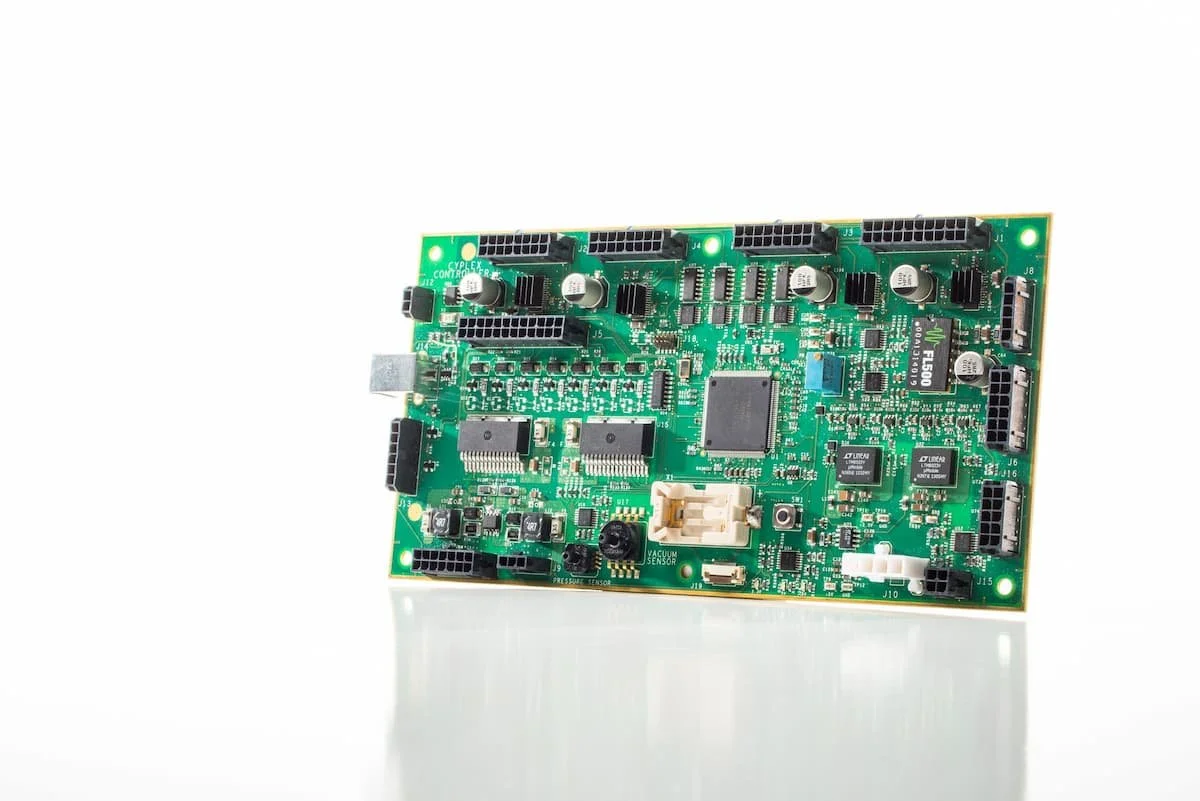 Green electronic circuit board with multiple integrated chips and connectors.