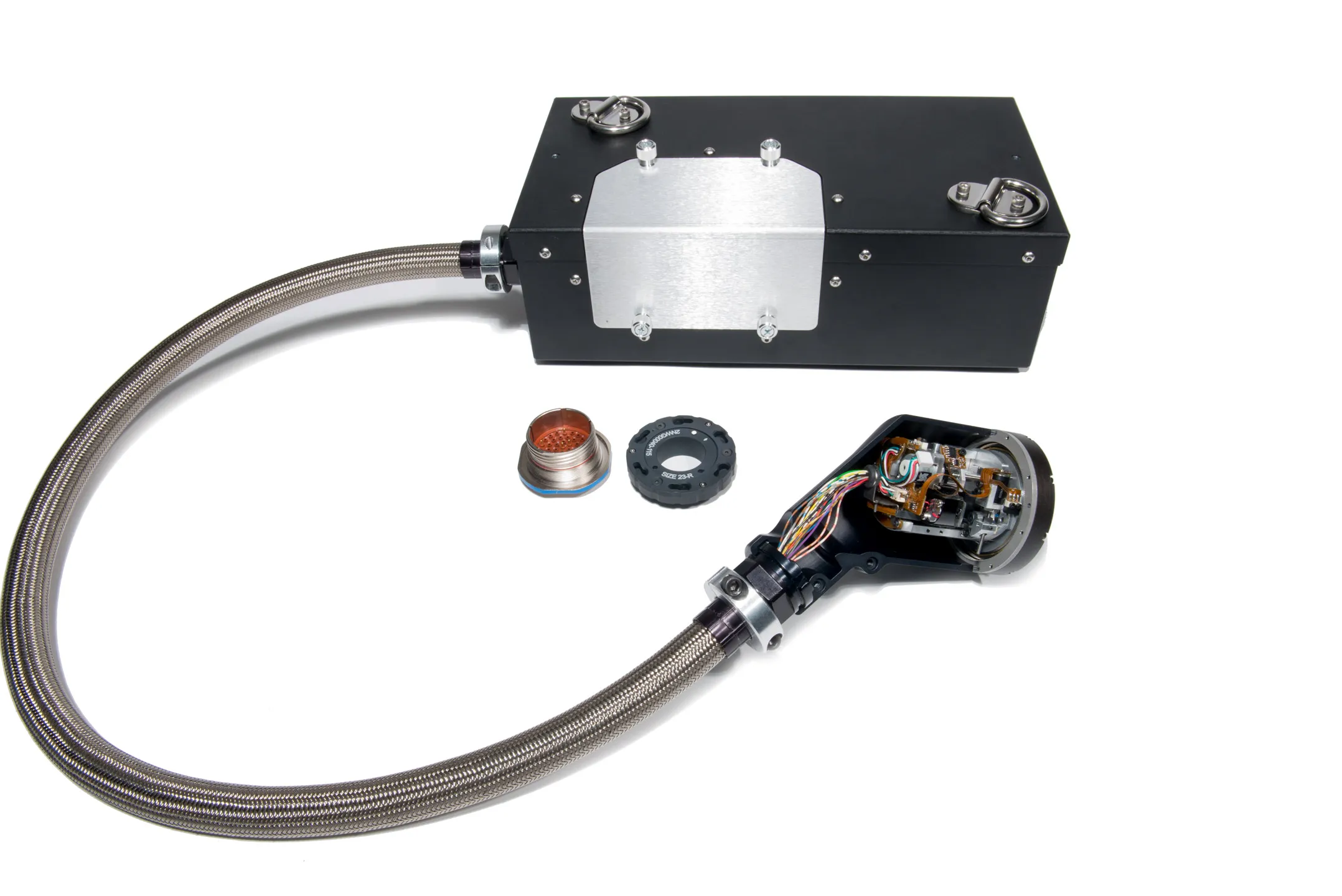 Black rectangular device connected to a flexible metallic braided cable with an opened cylindrical connector showing exposed wiring and two detached connector parts on a white background.