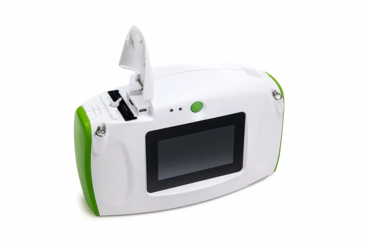 White handheld electronic device with green accents featuring a screen and an open compartment with ports.