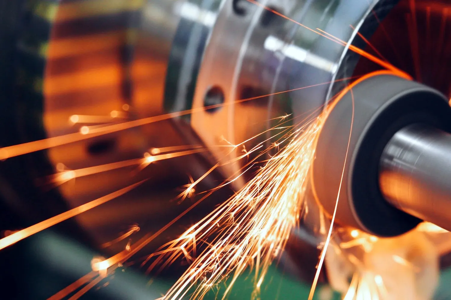 Close-up of sparks flying from a grinding machine polishing a metal surface.