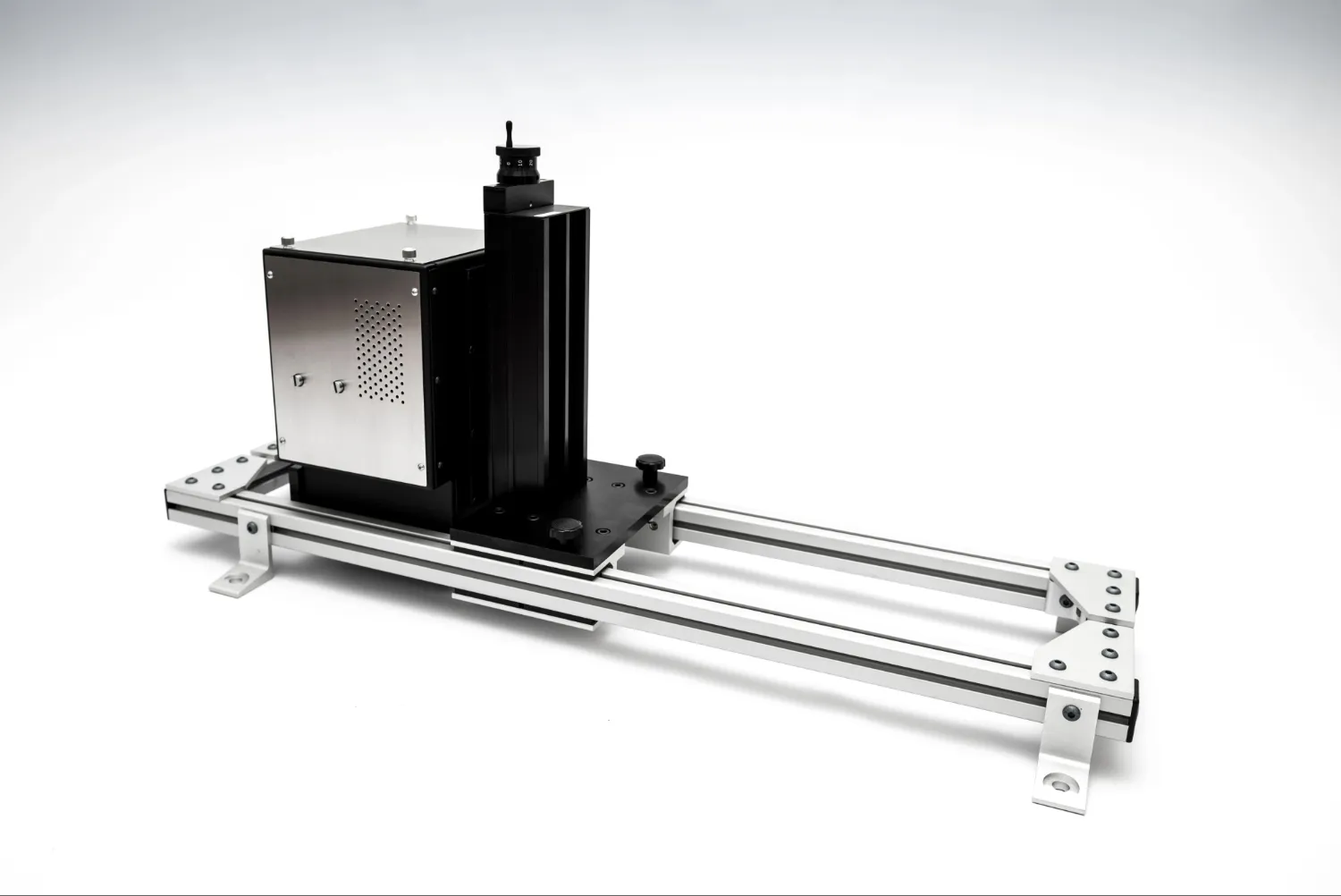 Compact industrial linear motion device with a black motor housing mounted on a silver aluminum rail frame.