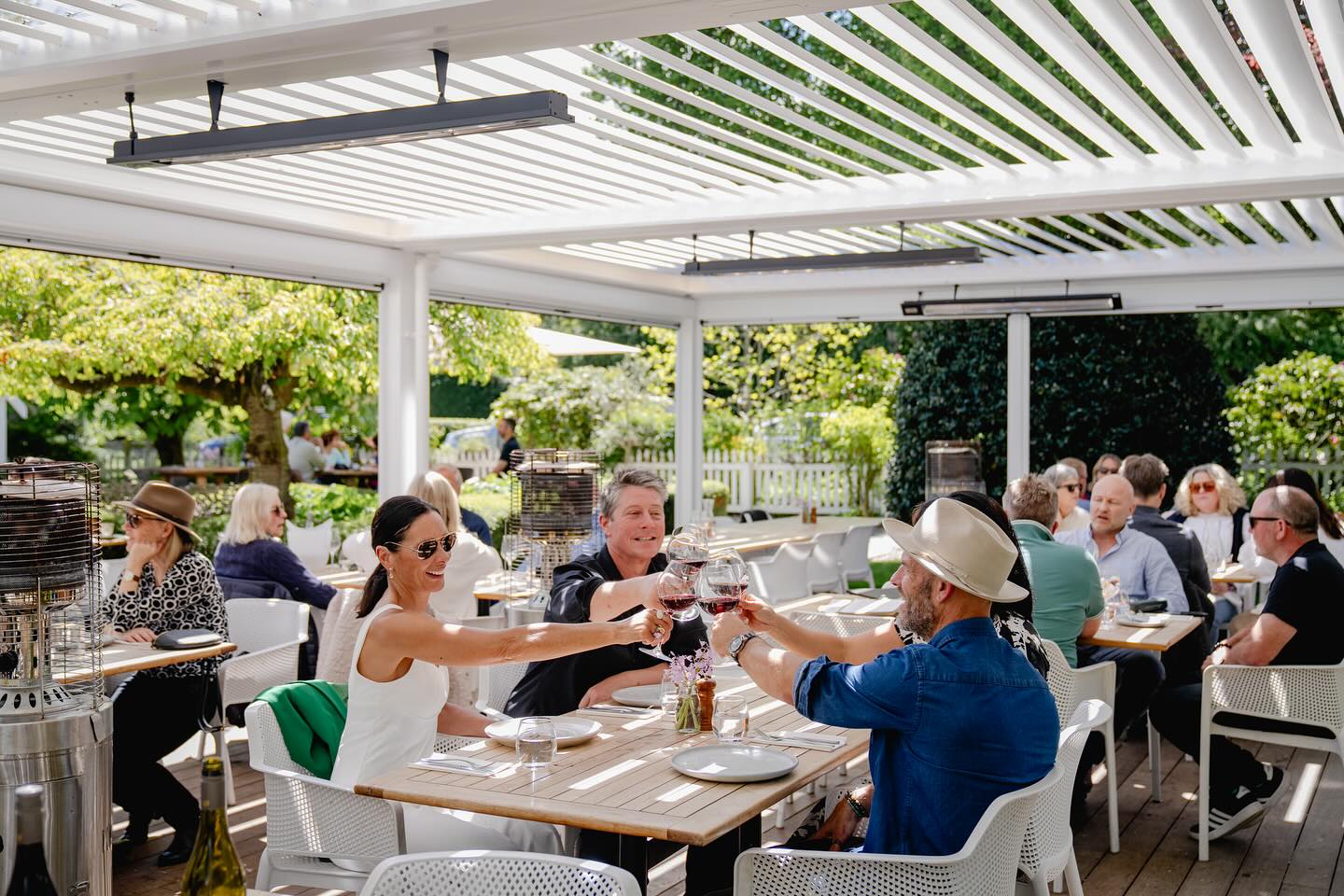 People clinking their wine glasses at Mora in Queenstown