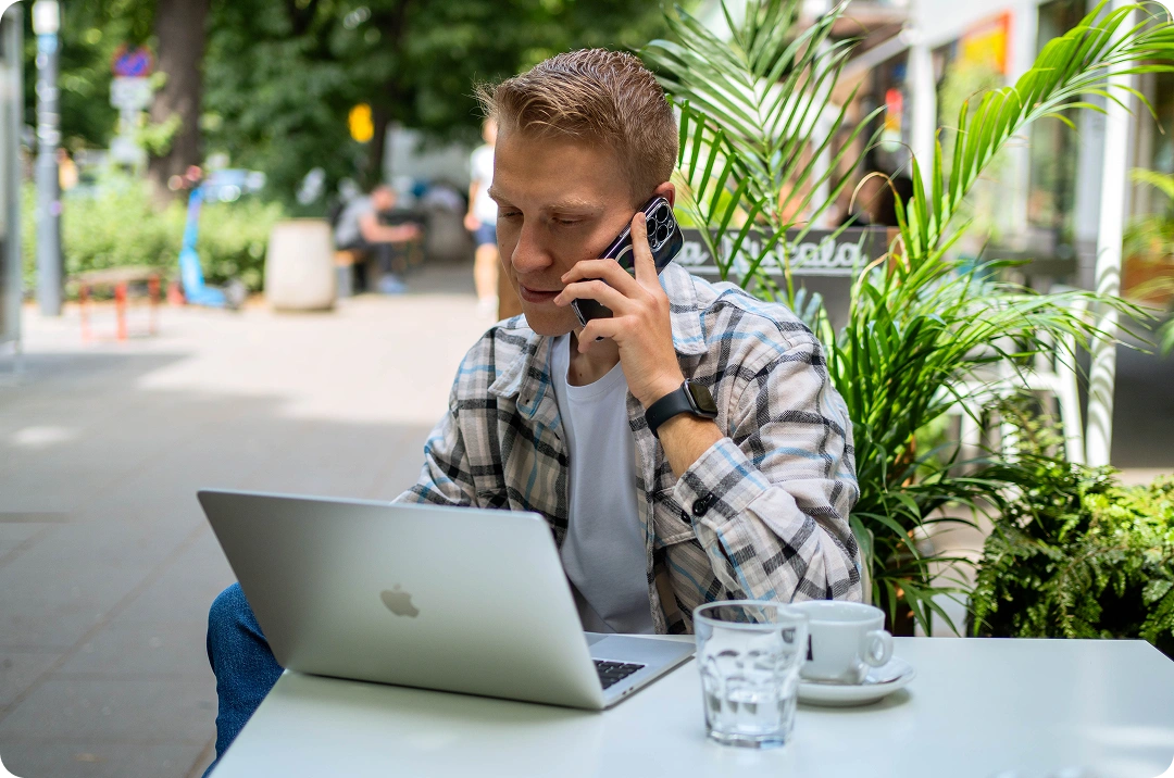 Man with cell and macbook in restaurant