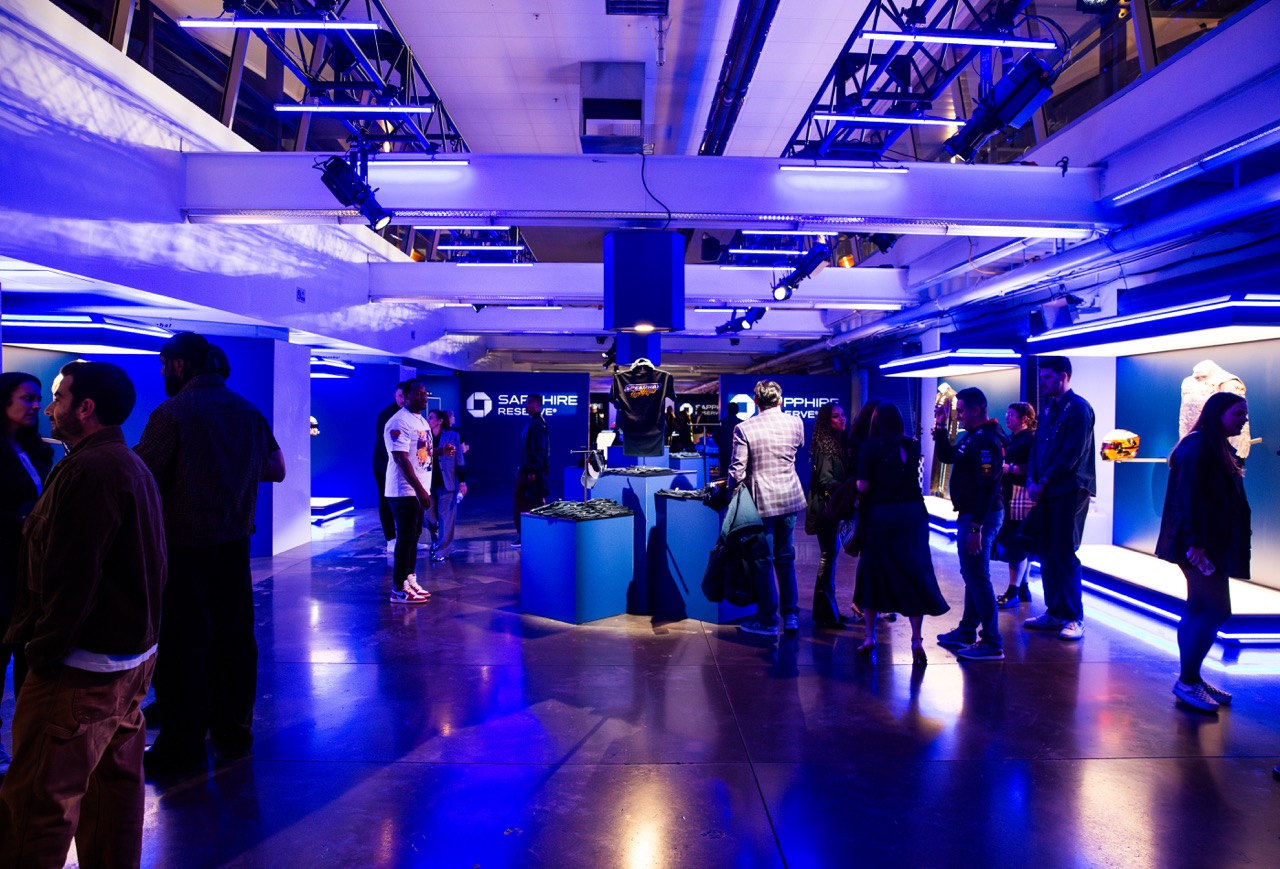 Event guests in a Chase Bank branded Formula 1 party, surrounded by custom displays featuring racing gear. 