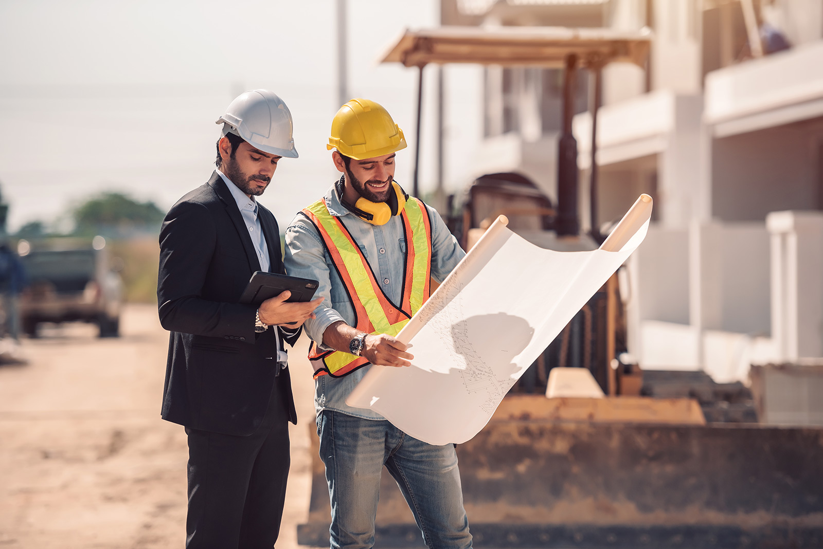 two construction workers holding a blue print