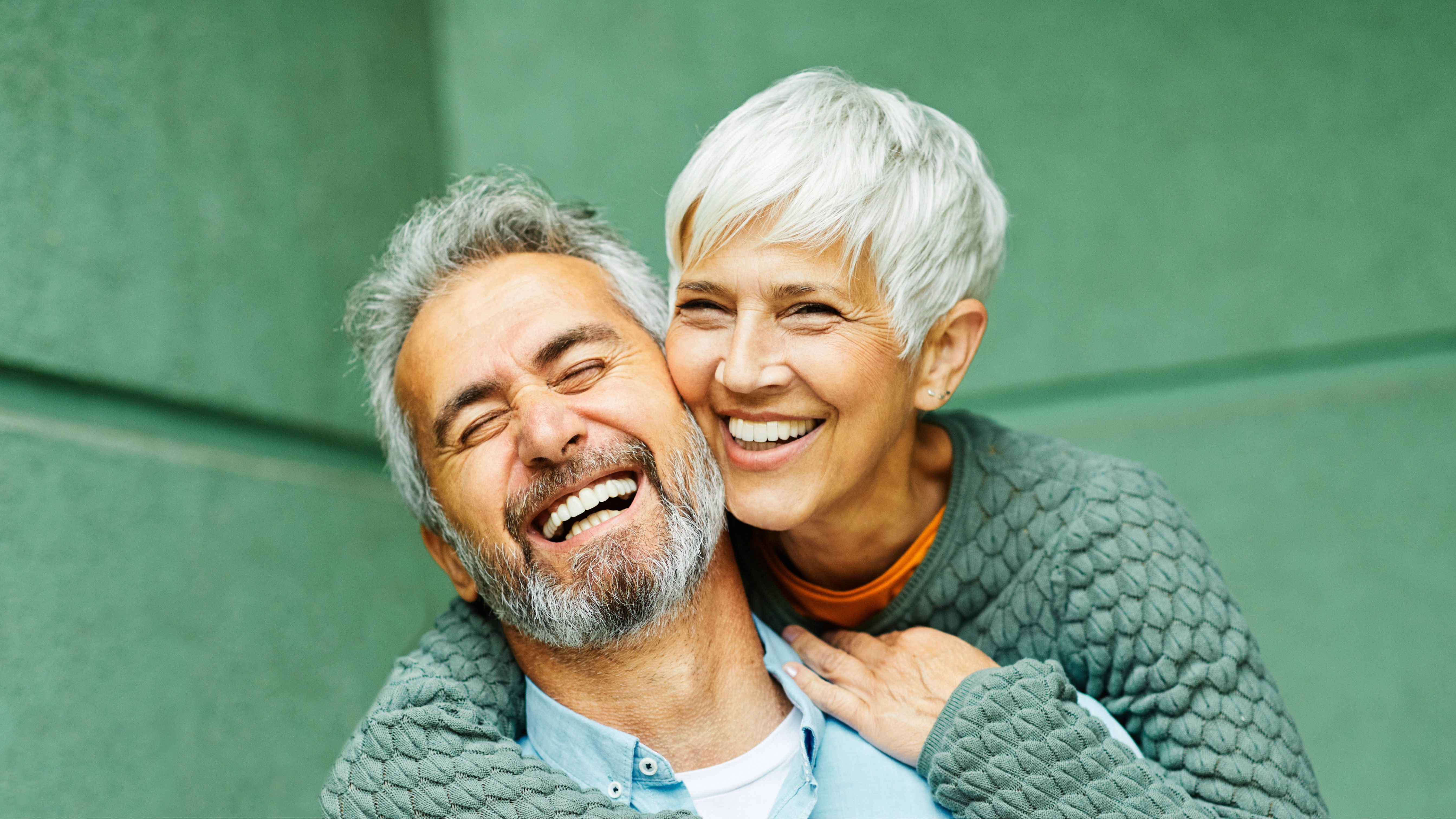 Smiling mature couple showing confident smiles after dental implants, highlighting restorative care from the best dentist in Pflugerville, TX, for long-lasting oral health and natural-looking results.